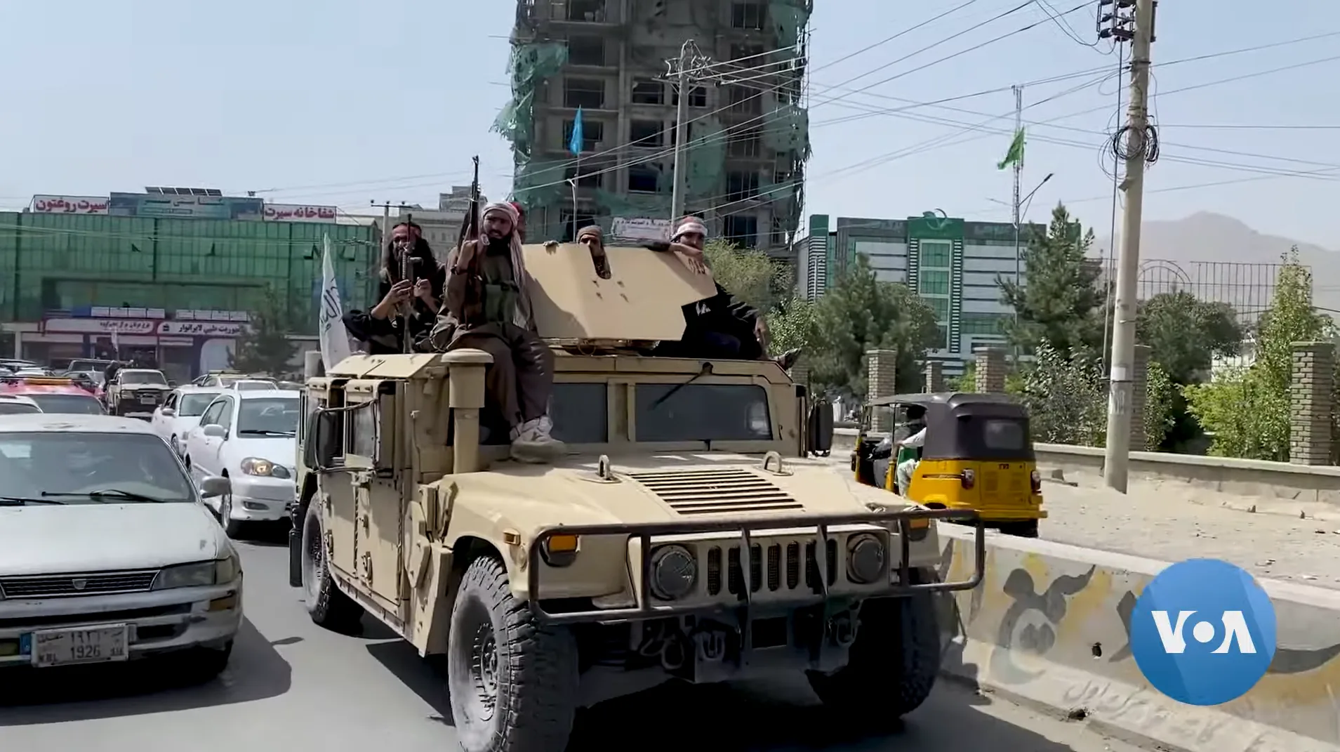 Taliban fighters riding in a Humvee on a Kabul street in August 2021